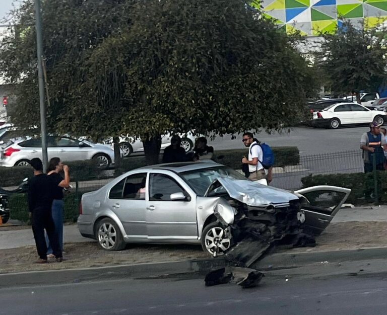 Jetta golpeado por un camión de transporte de personal derriba un señalamiento y termina sobre un camellón
