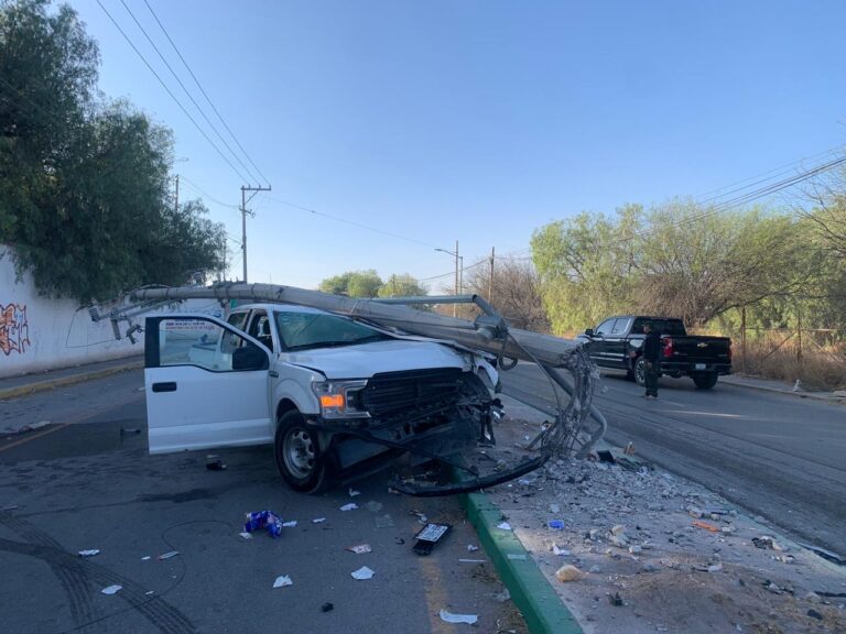 Conductor derriba poste y le cae encima de su camioneta